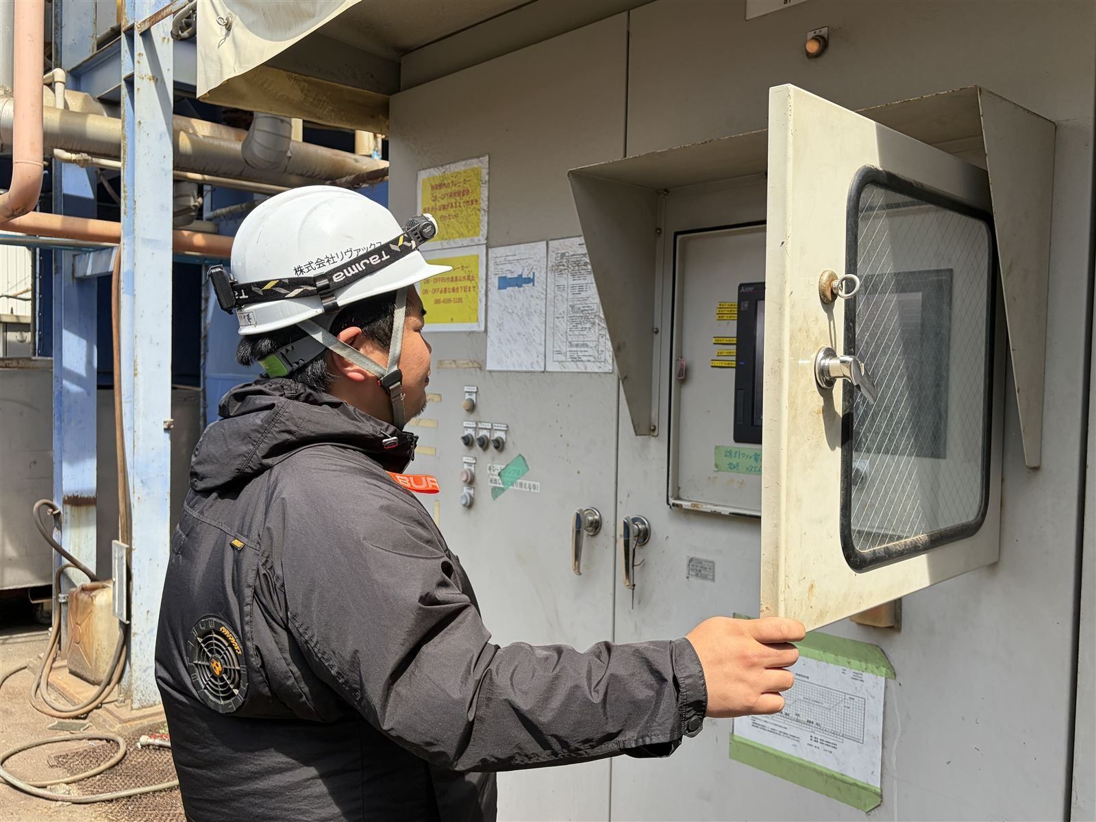 乾燥プラントの操作盤を確認する社員